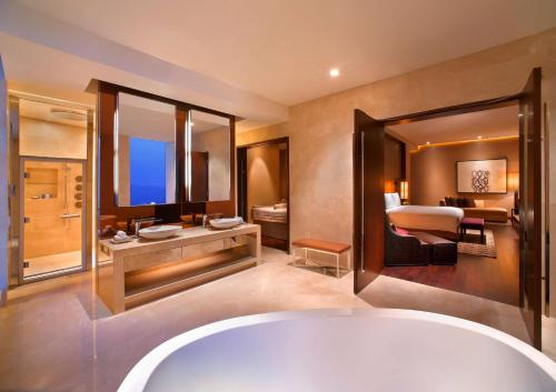 a bathroom with a large tub and a large mirror at Grand Hyatt Macau in Macau