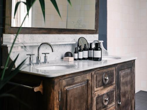 a bathroom sink with bottles of wine on it at Eco Hotel Plantage Rococo in Velsen-Zuid
