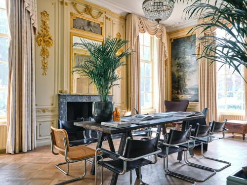 een eetkamer met een tafel en stoelen en een open haard bij Eco Hotel Plantage Rococo in Velsen-Zuid