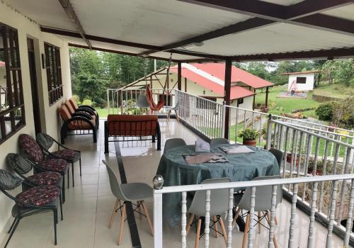 a porch with chairs and a table on a balcony at Finca Villa Elenita in Sasaima