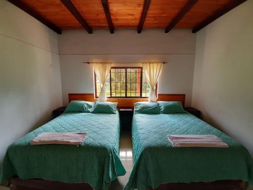 a bedroom with two beds and a window at Finca Villa Elenita in Sasaima