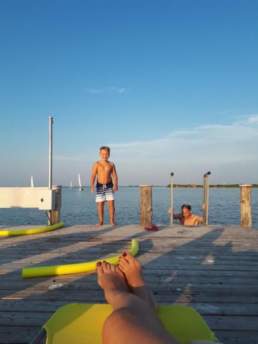 a man standing on a dock with a woman laying on a raft at Gut Zentgraf in Mörbisch am See