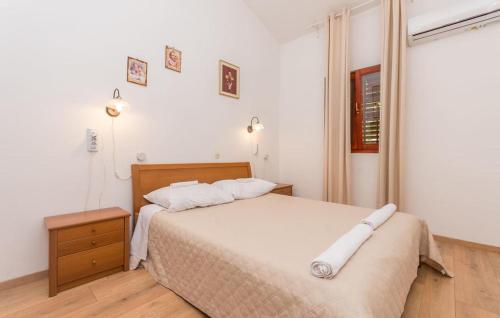 um quarto com uma cama grande e lençóis brancos em Kuća za odmor em Sveti Filip i Jakov