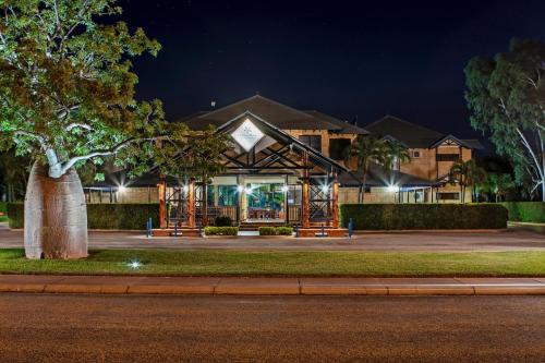 a park with a tree and a building at Blue Seas Resort in Broome