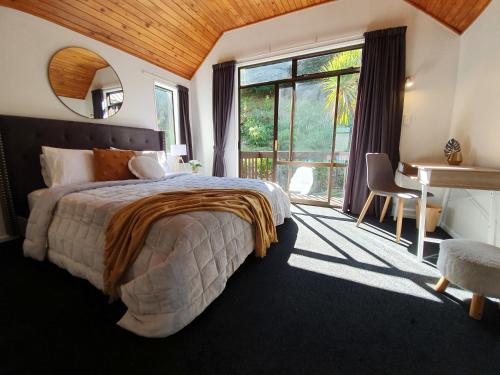 a bedroom with a bed and a desk and a window at Million dollar view in Queenstown