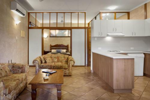 布魯姆的住宿－藍色海洋度假酒店，厨房以及带沙发和桌子的客厅。