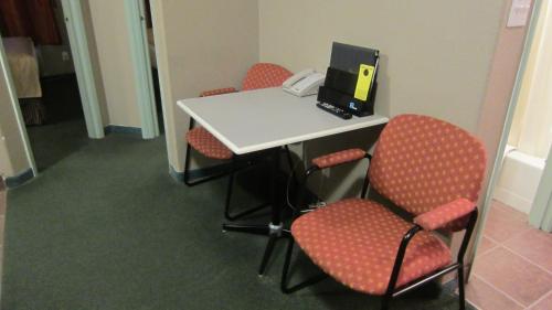 a room with a table with chairs and a laptop at Super 8 by Wyndham Revelstoke BC in Revelstoke