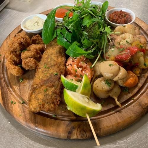 a plate of food with fish and vegetables on a table at Essex Arms in Huntly