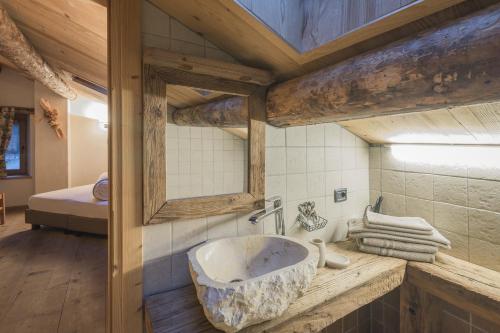 Habitación con baño con lavabo grande de piedra. en Agriturismo Baita De L'ALL en Valdidentro