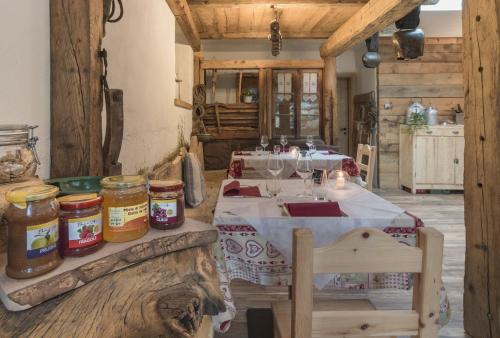 una sala da pranzo con tavolo e barattoli di miele di Agriturismo Baita De L'ALL a Valdidentro