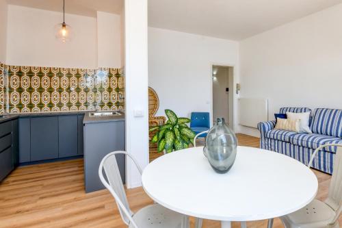 Apartament obejmuje kuchnię oraz salon z białym stołem i krzesłami. w obiekcie BELLAVISTA - Garda Leisure w mieście Salò