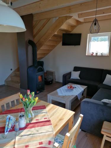 a living room with a table and a wood stove at Domki pod Derkaczem in Wünschelburg