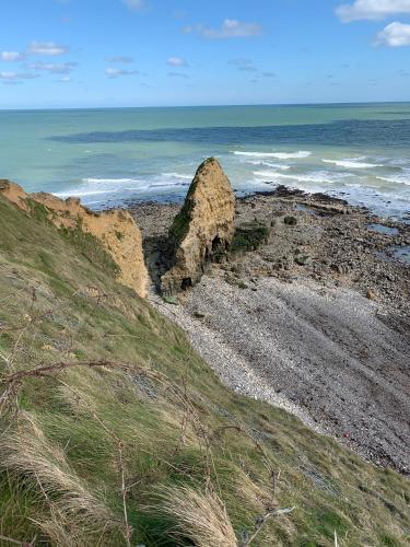 a large rock on a beach near the ocean at Manoir de l’Ormel Omaha Beach in Vierville-sur-Mer