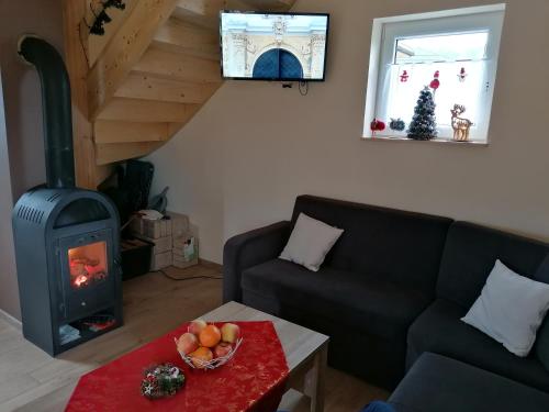 a living room with a couch and a wood stove at Domki pod Derkaczem in Wünschelburg