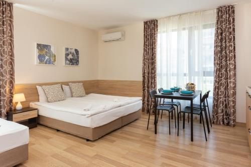 Un dormitorio con una cama y una mesa con sillas. en Apartments Flora 1, en Burgas