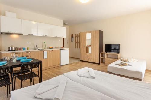 a kitchen and a living room with a bed and a table at Apartments Flora 1 in Burgas City