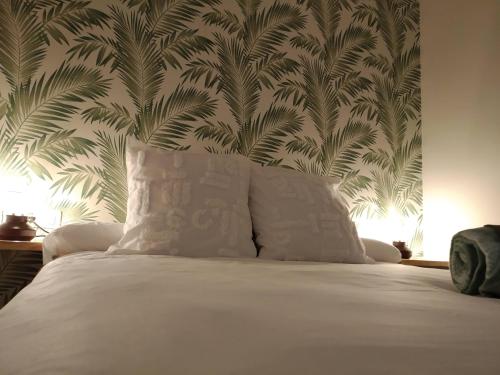 a bed with a white pillow in a bedroom with a wallpaper at Mirador de Alcañiz in Alcañiz