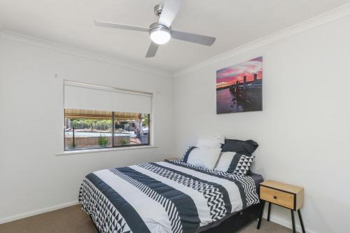 a bedroom with a bed, a desk, and a painting on the wall at Gossan Street Units in Broken Hill