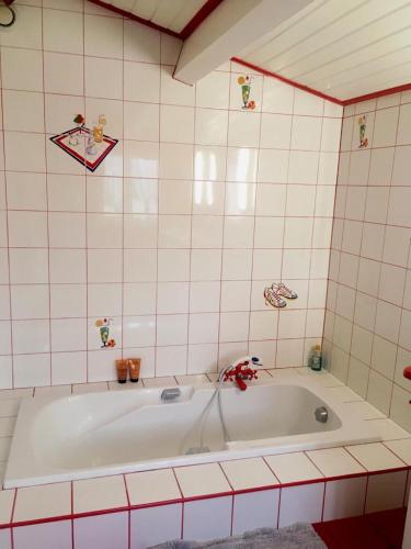 La salle de bains est pourvue d'une baignoire et de carrelage rose. dans l'établissement L Océan En Vendée, à Avrillé
