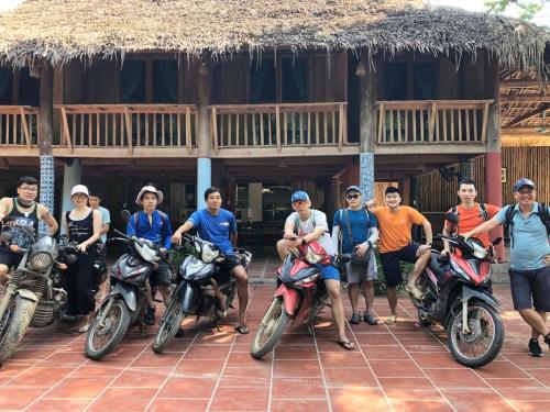 a group of people sitting on motorcycles in front of a building at LePont Mu Waterfall Bungalow in Hòa Bình