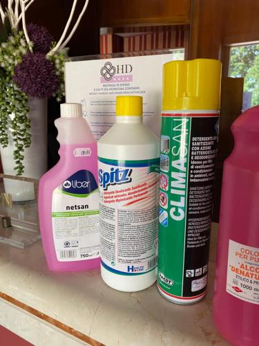 three bottles of glue sitting on top of a shelf at Hotel Daniel in Basiano
