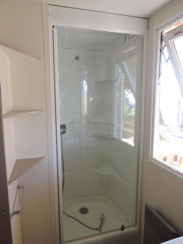 une douche avec une porte vitrée dans une salle de bain dans l'établissement Mobil-Home climatisé 6p Lac de Mimizan-Aureilhan Rivages des Landes 4 étoiles, à Aureilhan