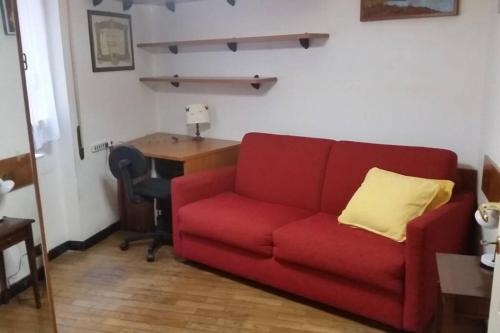 a red couch in a living room with a desk at MAREBLU Rapallo Mare in Rapallo