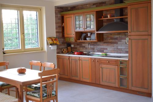 a kitchen with wooden cabinets and a table with a dining room at B&B Bee in Frascati