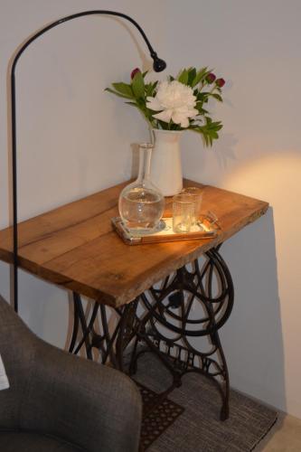 a table with a vase of flowers and a lamp at Antica Sosta dei Viandanti in Cadenazzo
