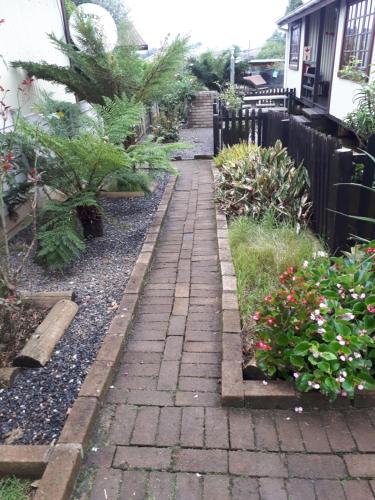 a brick path in a garden with flowers at Havana Nights in Graskop