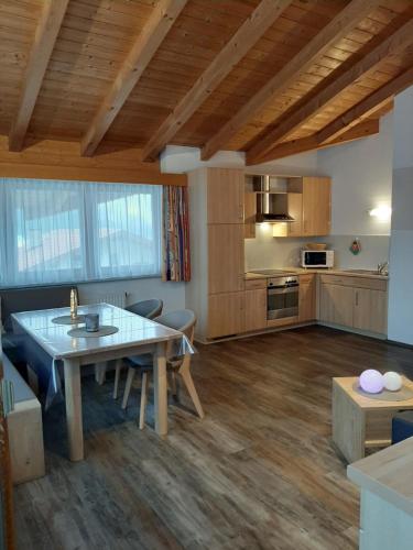 ein Wohnzimmer mit einem Tisch und einer Küche in der Unterkunft Apart Birgit in Pfunds