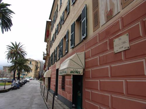 a red building with a sign for a hotel on a street at MAREBLU Rapallo Mare in Rapallo