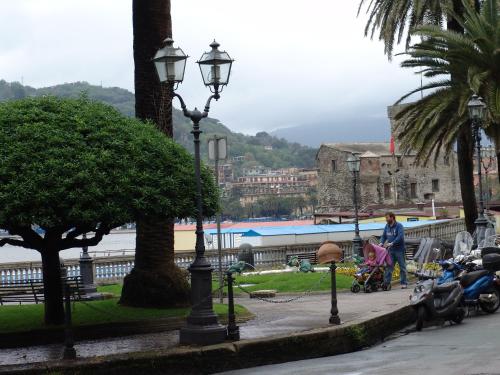a woman walking with a baby in a stroller on a city street at MAREBLU Rapallo Mare in Rapallo