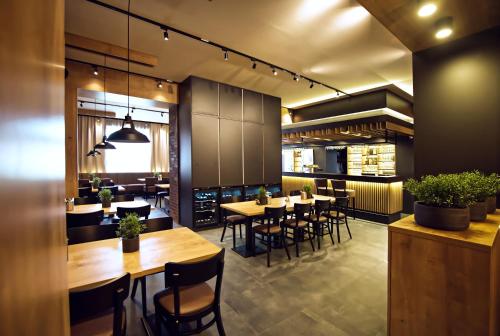 a restaurant with tables and chairs and a kitchen at Restaurace a Penzion Praha in Dolní Dunajovice
