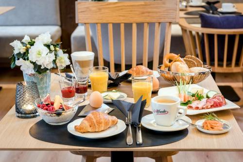 einen Holztisch mit Frühstückszutaten und Getränken darauf in der Unterkunft Hotel Krone in Bretten