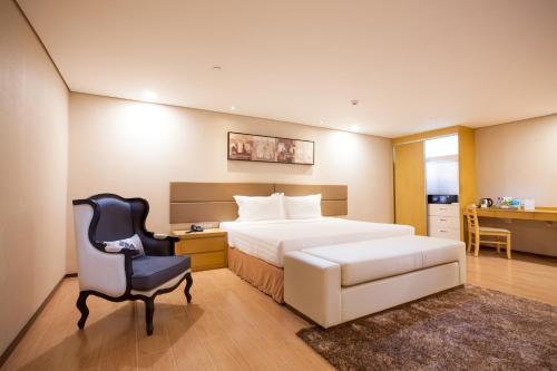 a bedroom with a bed and a desk and a chair at Jinjiang Inn - Makati in Manila