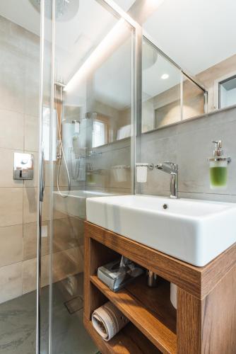a bathroom with a white sink and a shower at Hotel Matterhorn Inn in Täsch