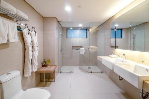 a bathroom with two sinks and a shower and a toilet at Jinjiang Inn - Makati in Manila