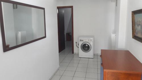 a bathroom with a washing machine and a mirror at Periyali in Keratea