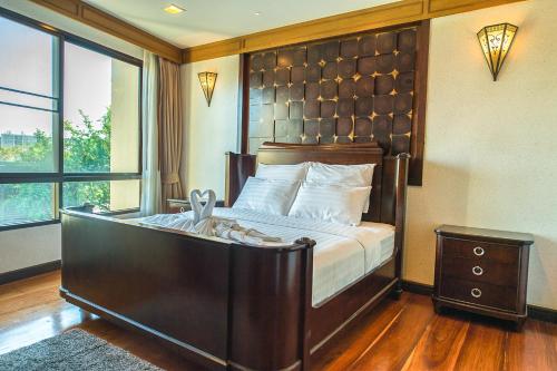 a bedroom with a large bed with a wooden headboard at Marrakesh Huahin 4bedrooms suite with Jacuzzi 208 in Hua Hin