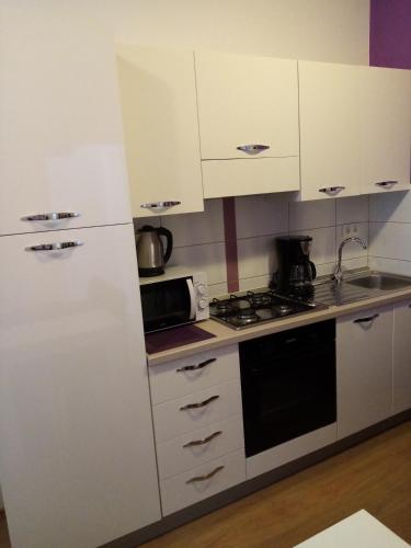 a kitchen with white cabinets and a stove top oven at Tomena apartments in Trogir