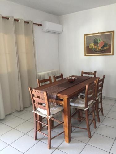 a dining room with a wooden table and chairs at Periyali in Keratea