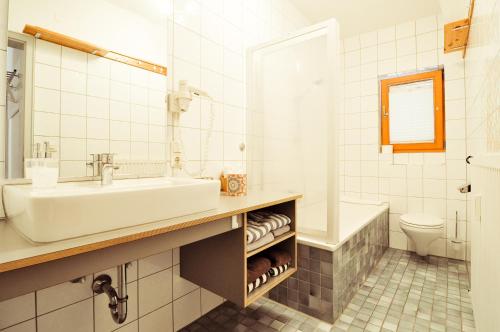 a bathroom with a sink and a tub and a toilet at Ferienwohnungen Evi Huber in Oberammergau