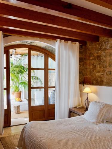 a bedroom with a large bed and a window at Cases de Son Barbassa Hotel & Restaurant in Capdepera
