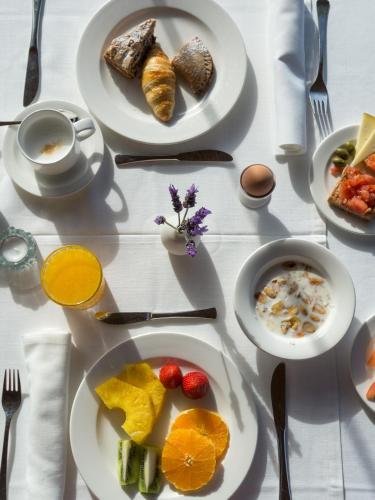 een witte tafel met borden voedsel erop bij Cases de Son Barbassa Hotel & Restaurant in Capdepera