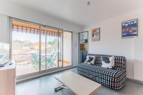 una sala de estar con un sofá y una mesa en Le coeur de Royan studio 2 étoiles, en Royan