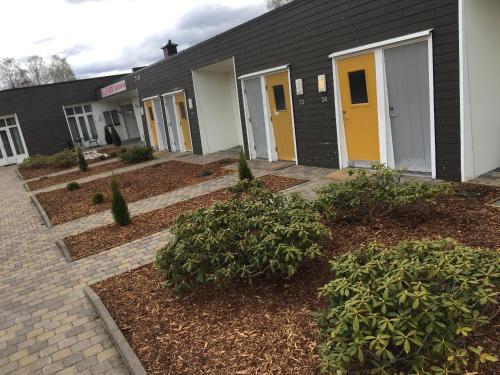 a building with yellow doors and bushes in front of it at Evje Park in Evje