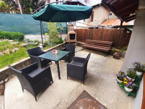 a patio with a table and chairs and a bench at Apartament Rustic in Sinaia