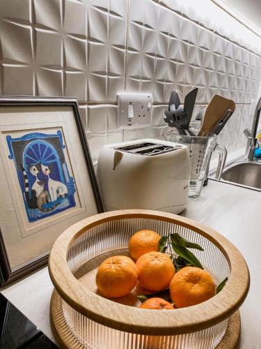 a bowl of oranges on a kitchen counter next to a sink at Cozy place in Larnaka