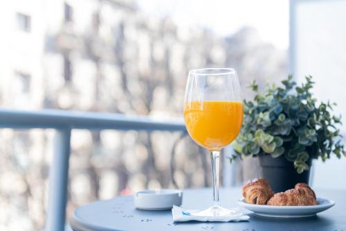 a glass of orange juice next to a plate of food at Aparthotel Atenea Calabria in Barcelona
